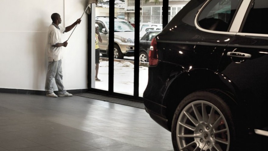  Washing the windows of the Porsche dealership on Avenue Amilcar Cabral in centr