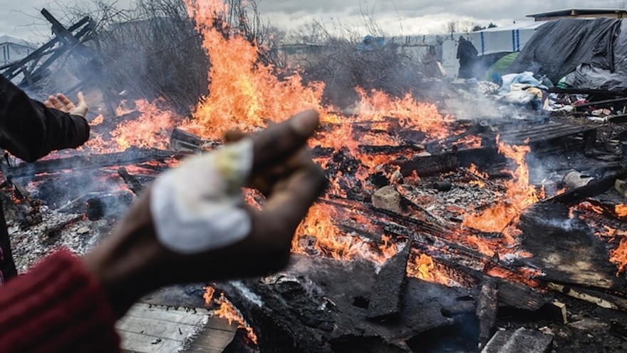 Calais, France, March 2016: Shelters set ablaze in protest of French government’s decision to clear the southern section of “The Jungle” camp