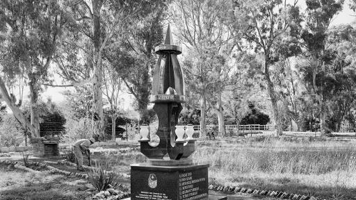  A modest square, carefully tended by the municipality, sown, at the time of this photograph with blue daisies, the borders of its paths neatly outlined by beer bottles. It is a memorial to local heroes killed in the struggle against apartheid.  Steynsberg, Eastern Cape. Image: David Goldblatt. 