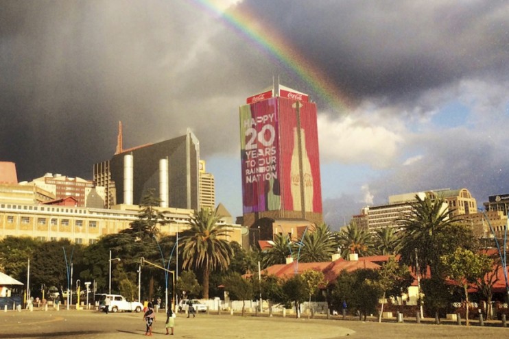 A real rainbow arcs over the sky above the Life Centre building in Johannesburg for Coca-Cola South Africa's "A Rainbow for the Rainbow Nation" campaign by FCB South Africa.