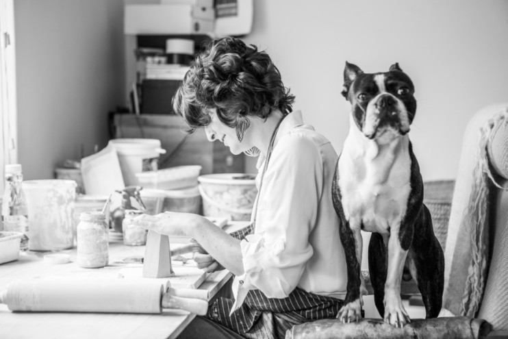 Alexia Klompje in her ceramic studio with Bruce Lee her Boston terrier