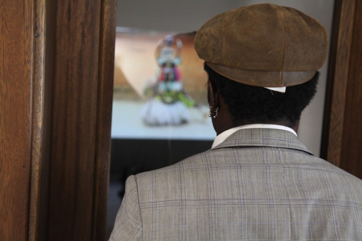 A visitor watches a video piece projected onto the wall in Ken Saro-Wiwa's old office.