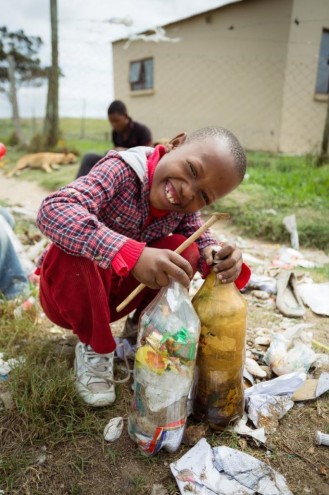 A young boy from Walmer Township displays his contribution to the EcoBricks project. 