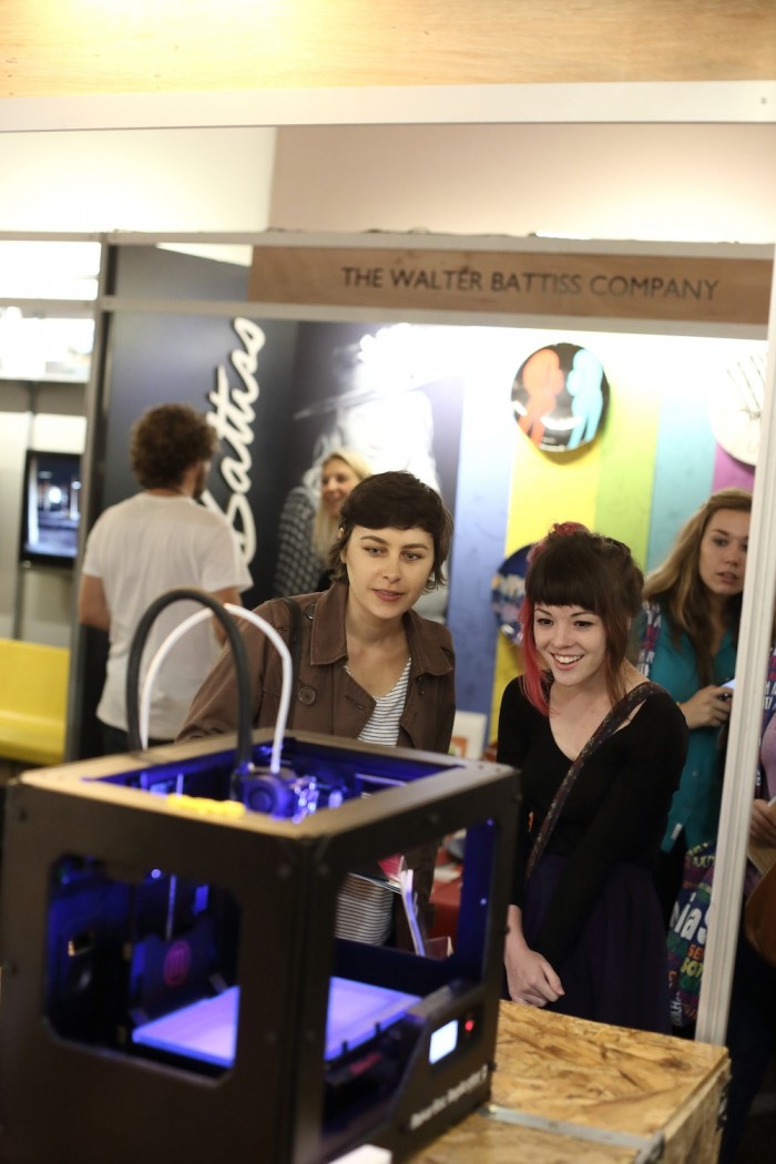 Design Indaba Expo 2014 visitors look on as Ignite 3D's Makerbot prints a 3D object. 