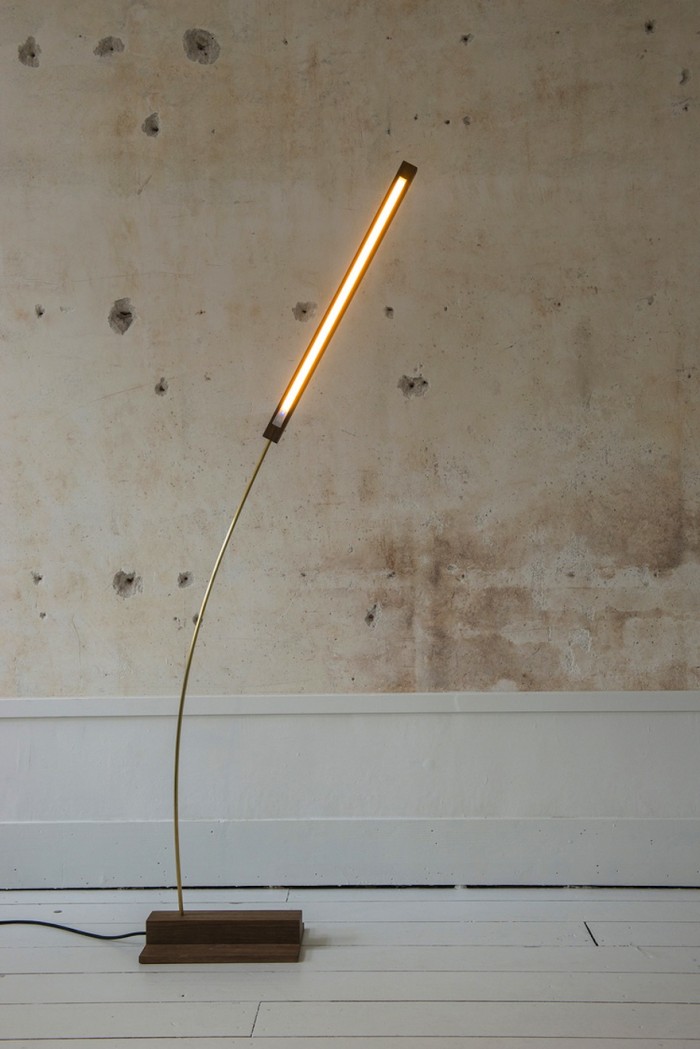 This brass and walnut wood lamp sways gently, mimicking a blade of grass in the wind. 