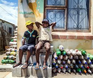 Two small children from Walmer Township in Port Elizabeth sit next to the EcoBricks that have been made for the Penguins Play and learn Centre. Image: https://www.thundafund.com/ecobrickexchange