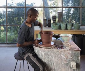 Ceramicist Chuma Maweni works at the potter's wheel at Art In The Forest in Constantia. Image curtesy of Jac de Villliers.