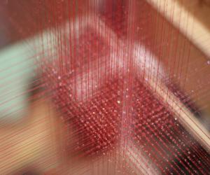 3D-weaving involves crisscrossing three-dimensional red strings