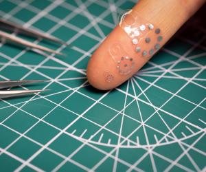 Image: Three variations of the soft, flexible ultrasound sticker device displayed on a finger. Image by Jiaqi Liu