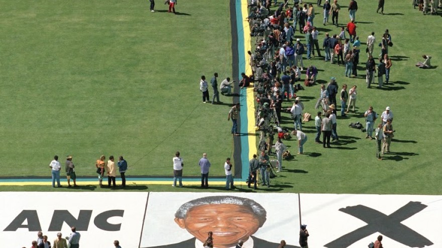 Graeme Williams, Portrait of Nelson Mandela painted on the grass of Soweto's largest football stadium during an election rally, 1994. Courtesy the artist. © Graeme Williams. 