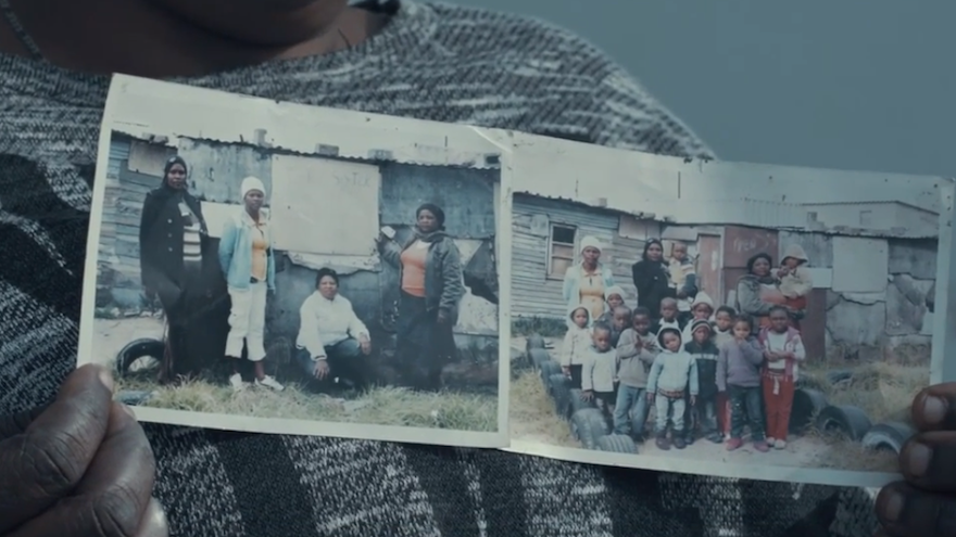 Principal of Three Sisters Educare holds up photos of the tiny shack where she started the school with 10 children.