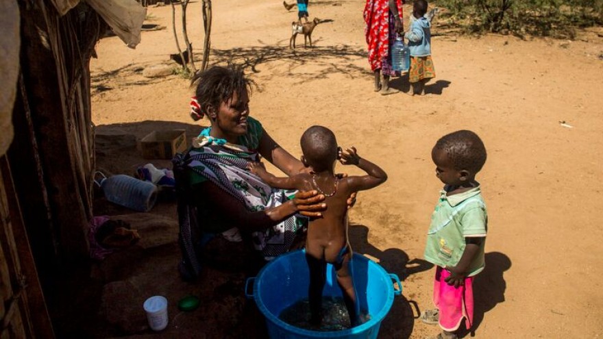 23-year-old Antonella bathes her baby Jakob outside her mud house.