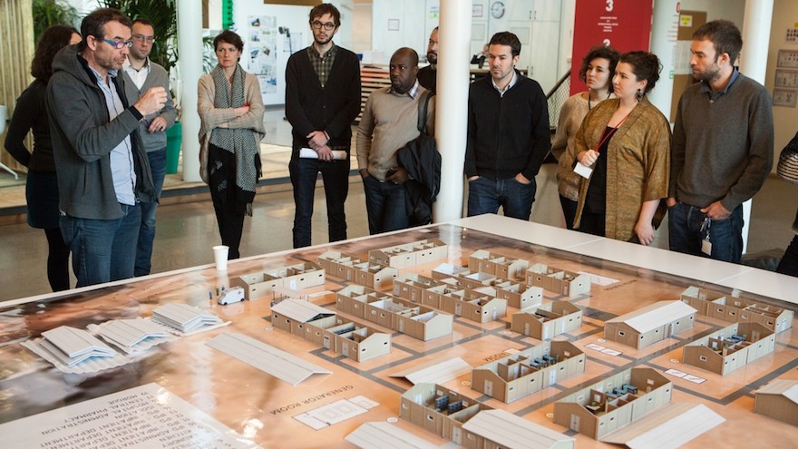 Jean Pletinckx, MSF Director of Logistics, explains to some MSF members the results of the project with the 3D printed model of Cantahay hospital. Image Alex Yallop