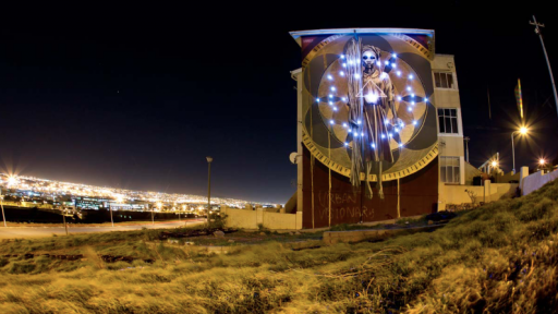Harvest mural by Faith47 lit up at night. Photo by Rowan Pybus @Makhulu_