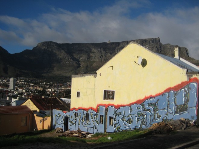 A piece of graffiti by artist Crave Arok set against the backdrop of Table Mountain. 