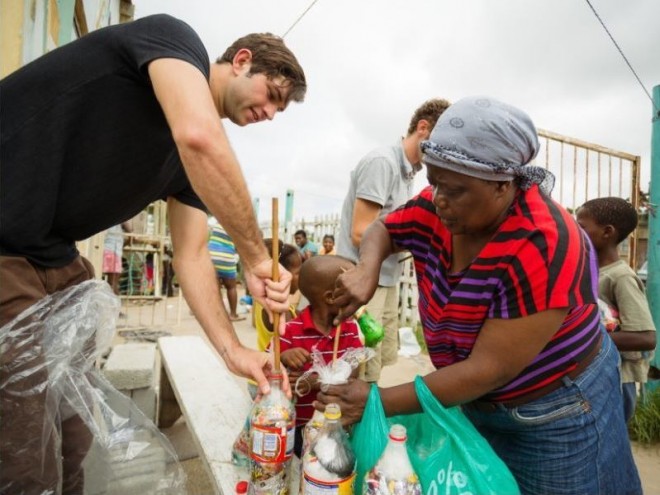 A woman from Walmer Township in Port Elizabeth is making EcoBricks with an EcoBrick volunteer. 