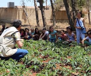 Nutrition education is key. School children and FAO staff discuss nutrition at a school garden in Hama, Syria. ©FAO/Wajdi Skaf