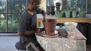 Ceramicist Chuma Maweni works at the potter's wheel at Art In The Forest in Constantia. Image curtesy of Jac de Villliers.